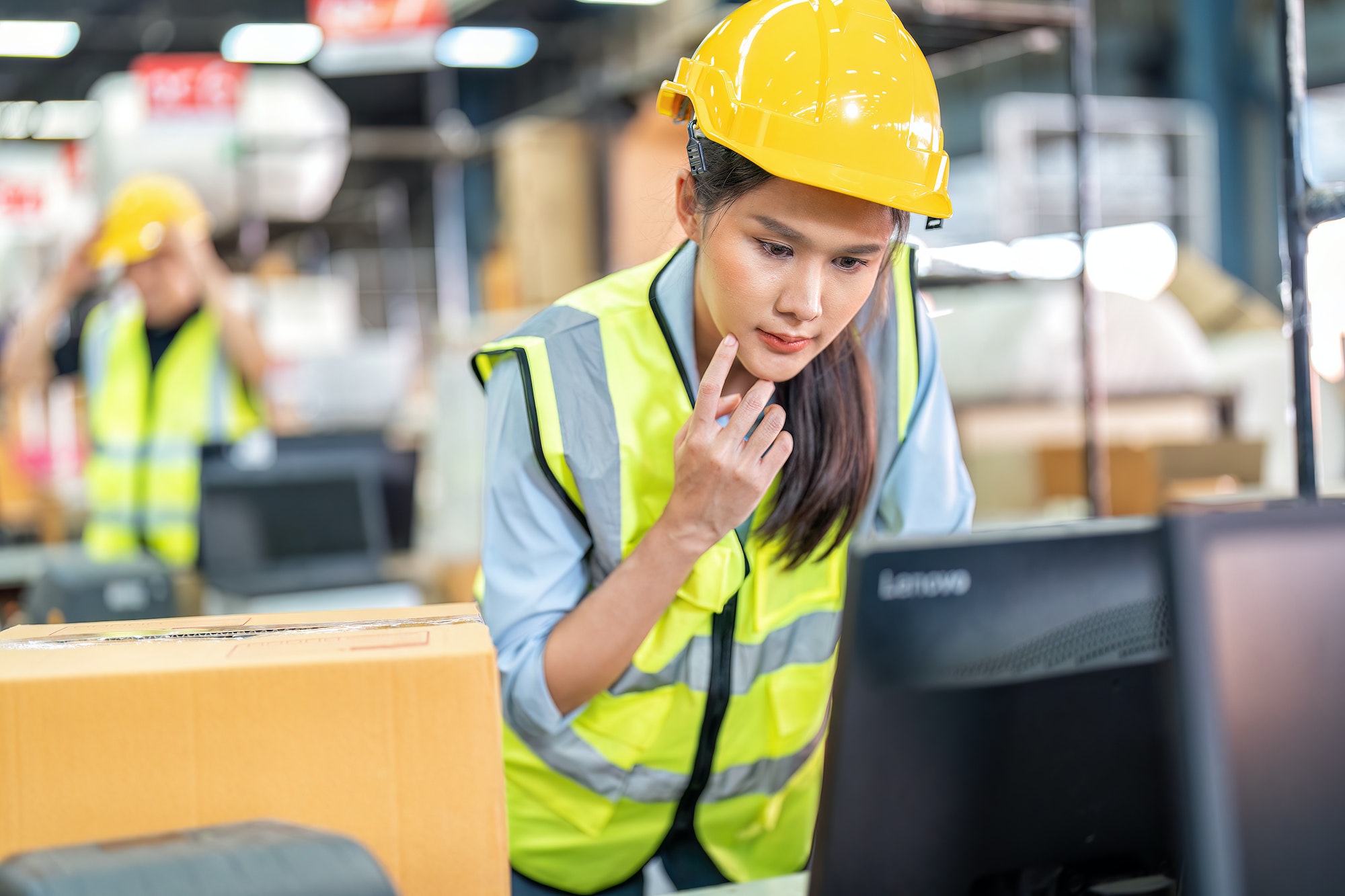 Cashier girl working in ware house calculation payment and stock balance check at computer screen